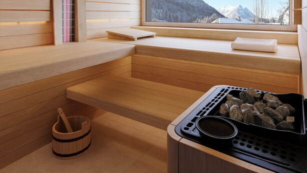A wooden sauna with a window, a thermometer, and a stone basin. - NOOK - Nature Hideaway (Bad Aussee)