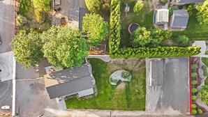 An aerial view of a residential area with a house, a swimming pool, and a well-maintained lawn.