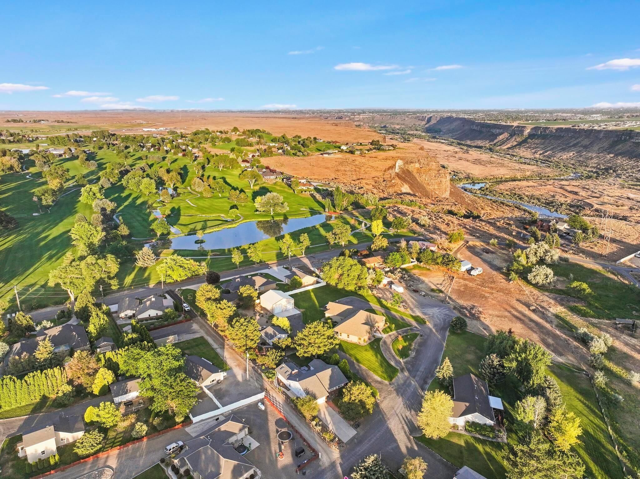 Luchtbeeld van een woongebied met huizen, wegen en een golfbaan.