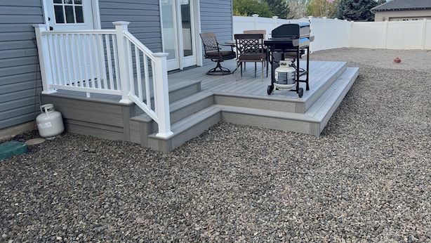 A house with a covered patio, a grill, and outdoor furniture.