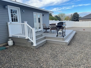 A house with a covered patio, a grill, and outdoor furniture.