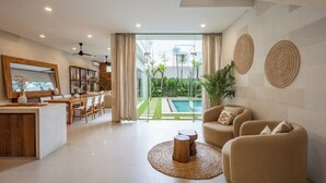 Ein modernes Wohnzimmer mit einer Couch, einem Couchtisch und einem Essbereich mit Tisch und Stühlen.