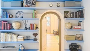 Eine Bibliothek mit Bücherregalen, einer Schreibmaschine und einem gerahmten Foto an der Wand.