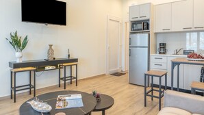 A modern kitchen with white cabinets, a built-in microwave, and a coffee maker. - Studio 'Next To The Wave 1' with Sea View and Private Terrace (Μυρτιές)