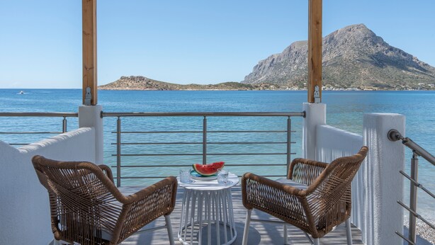 A balcony with wicker chairs, a small round table, and a watermelon on the table. - Studio 'Next To The Wave 1' with Sea View and Private Terrace (Μυρτιές)