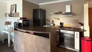 A compact kitchen with a central island, a refrigerator, microwave, stove, and oven. - 4-room apartment in the heart of Juan les Pins (Antibes)