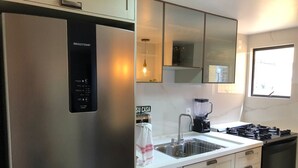 Et moderne køkken med stålemmer, en indbygget blender og et vindue med udsigt.