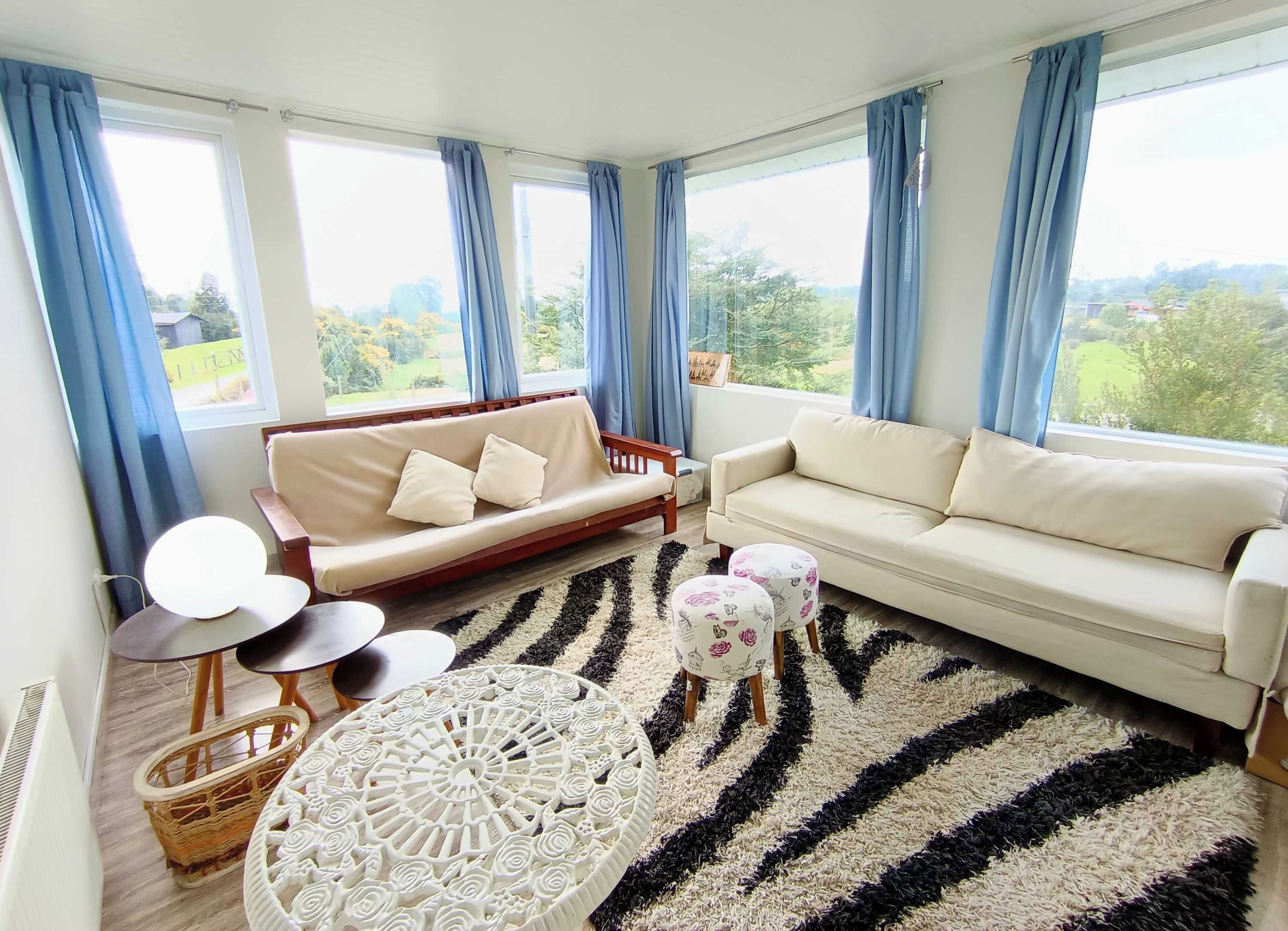 A modern living room with two sofas, a round coffee table, and a patterned rug.