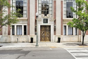 Fachada de edificio con una entrada grande y ornamentada, columnas de ladrillo y un letrero que dice 'The Miners National Bank'.