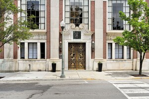 Fachada de edificio con una entrada grande y ornamentada, columnas de ladrillo y un letrero que dice 'The Miners National Bank'.