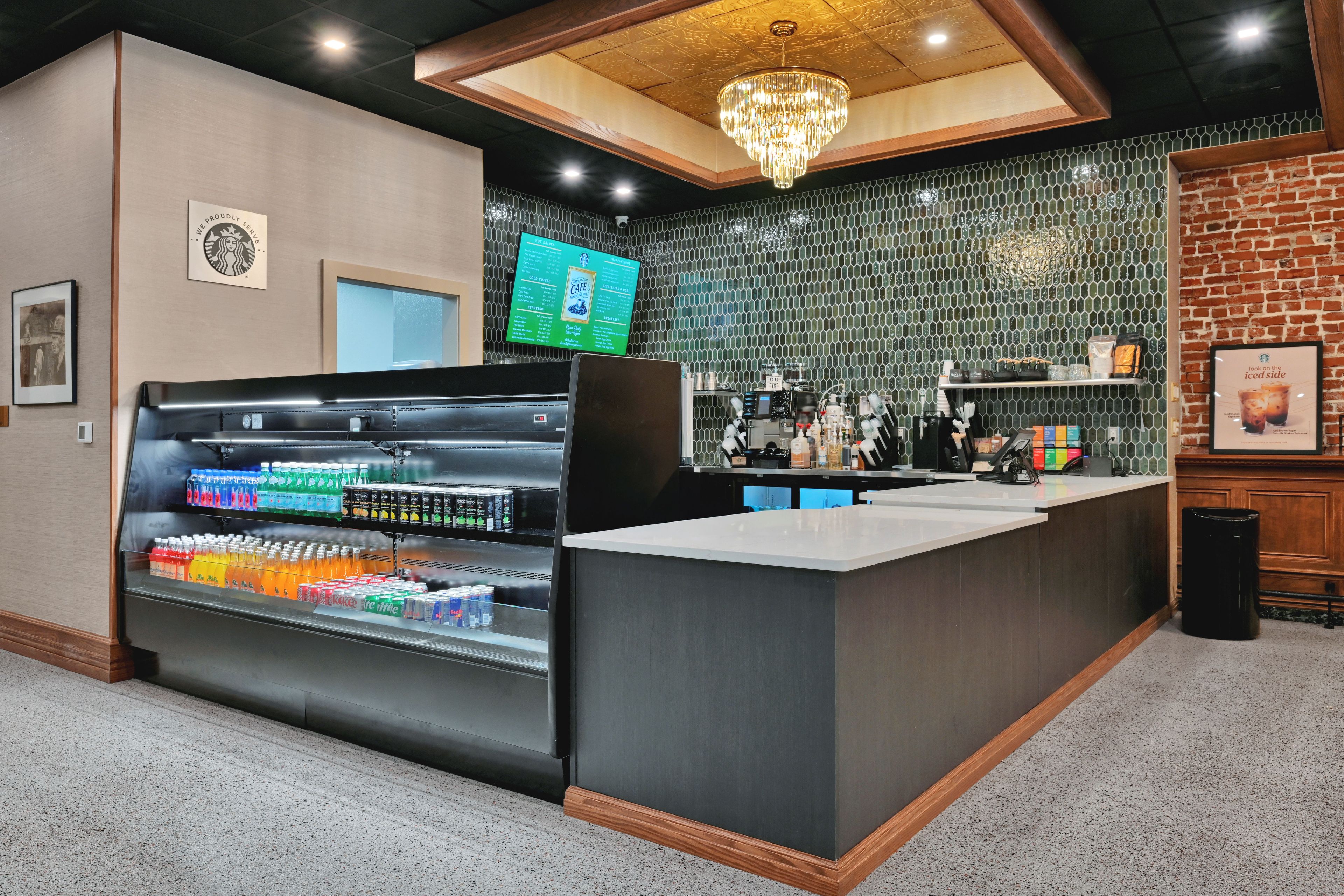 A modern bar area with a beverage display, a menu board, and a brick wall.