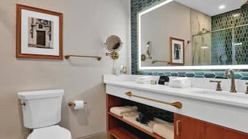 Un baño moderno con inodoro, tocador y un espejo grande.