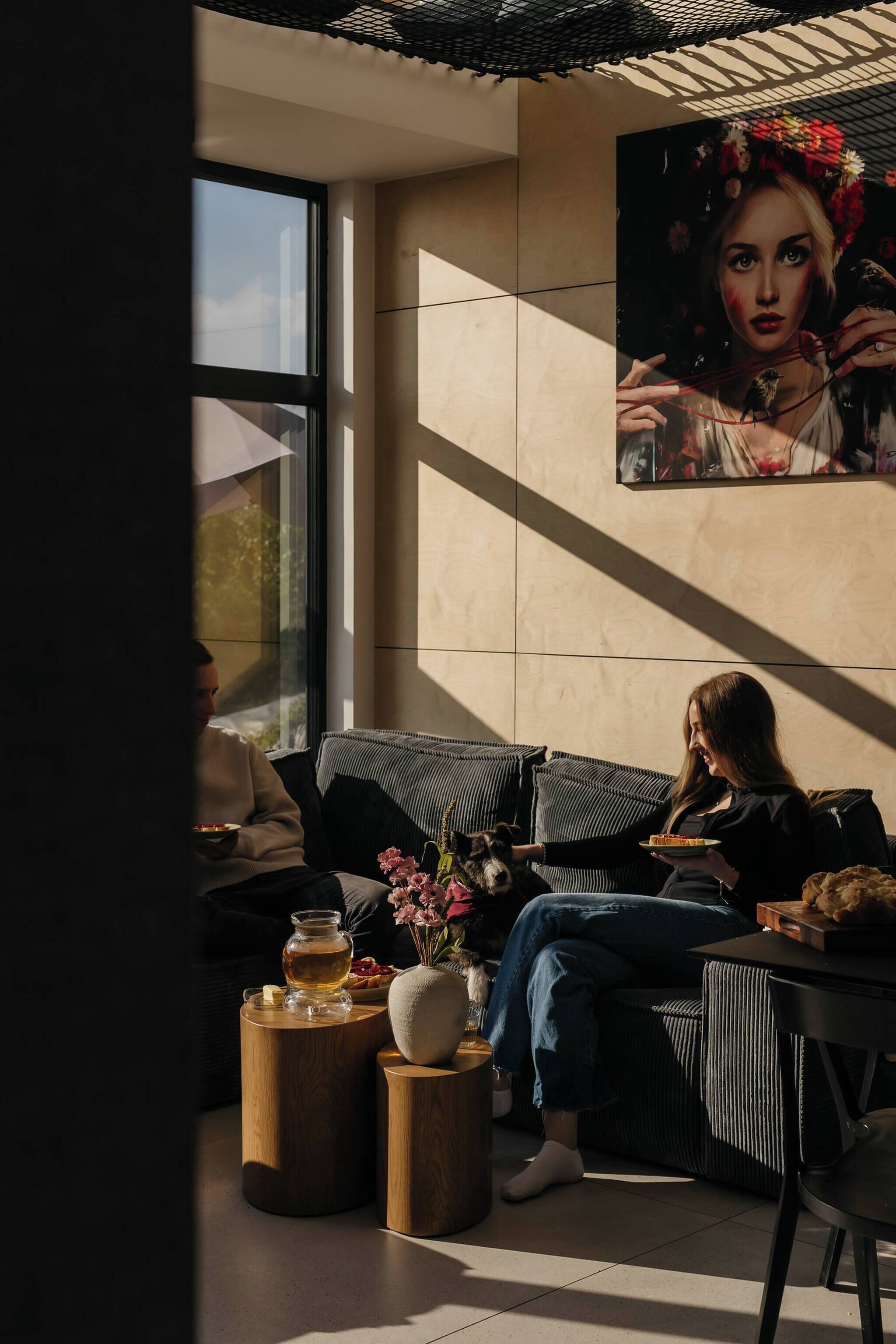 Ein modernes Interieur mit einer Couch, einem Tisch, einer Vase mit Blumen und einem Gemälde an der Wand.