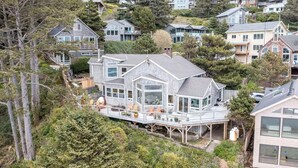A large house with a deck, surrounded by trees and other houses. - *New Listing* Breathtaking Views of Endless Ocean (Oceanside)