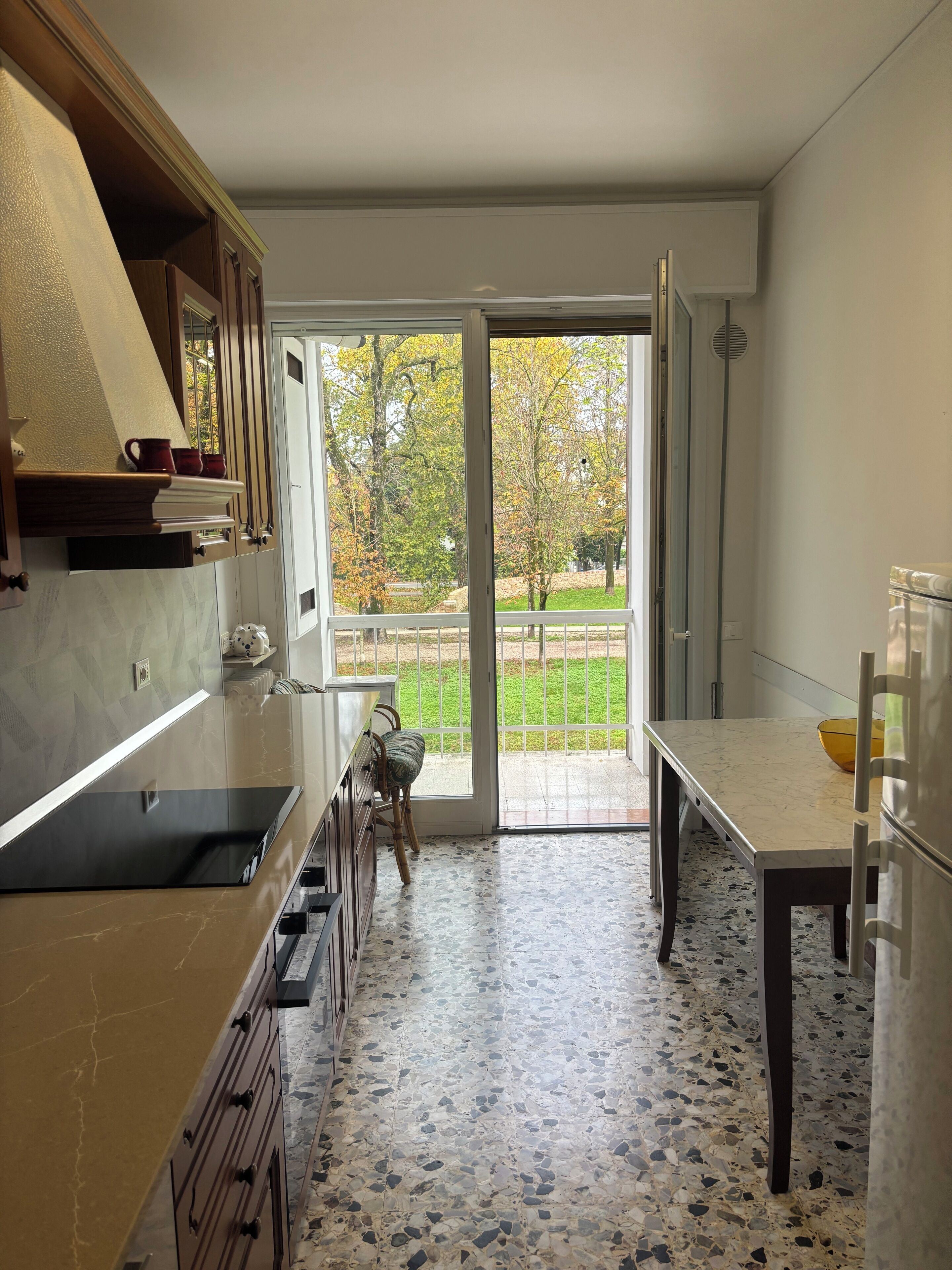 Una cucina moderna con una grande finestra, un'area pranzo e vista su un giardino.