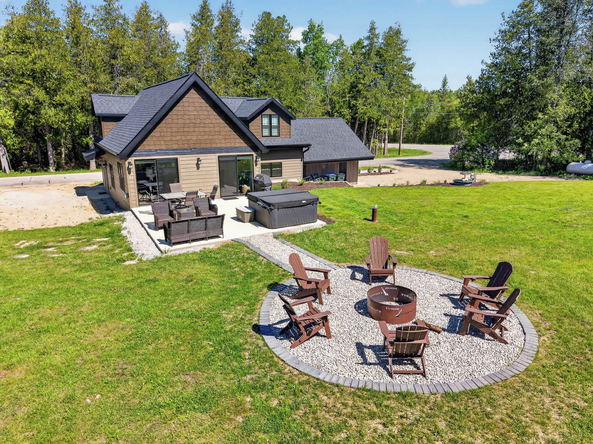 Une maison dotée d’un patio aménagé avec des meubles d’extérieur et un foyer.