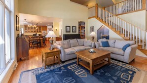 A spacious living room with a sofa, coffee table, and a staircase.