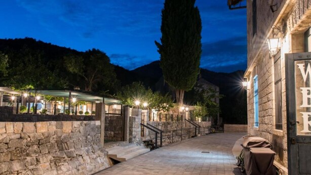 A stone pathway leading to a building with a sign that reads 'WATER.'