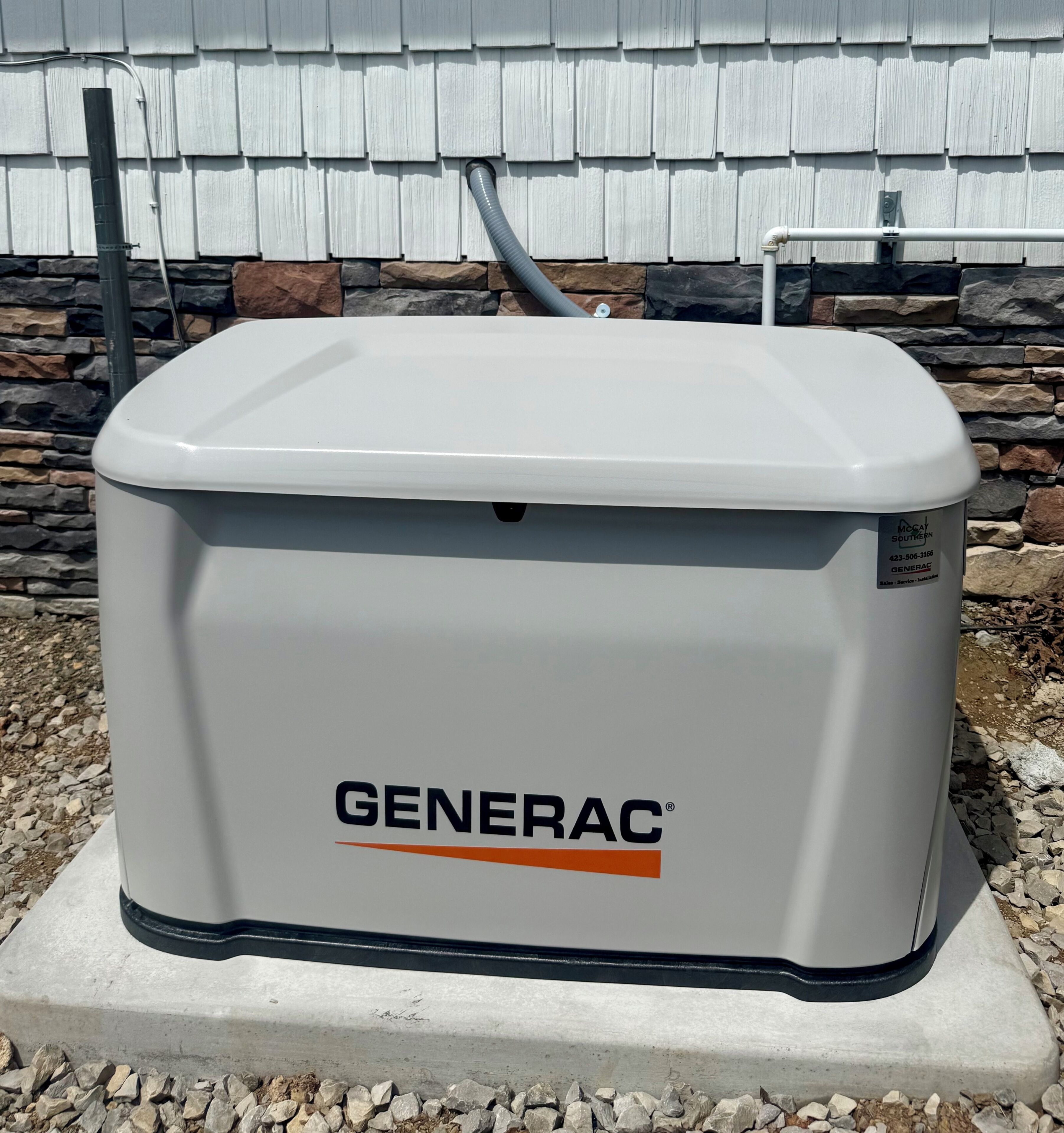 A Generac® generator on a concrete base outdoors.