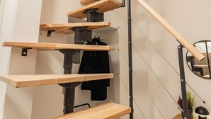 A modern spiral staircase with wooden steps and metal railings. - RentPlanet - Apartamenty Raciborska (Gliwice)