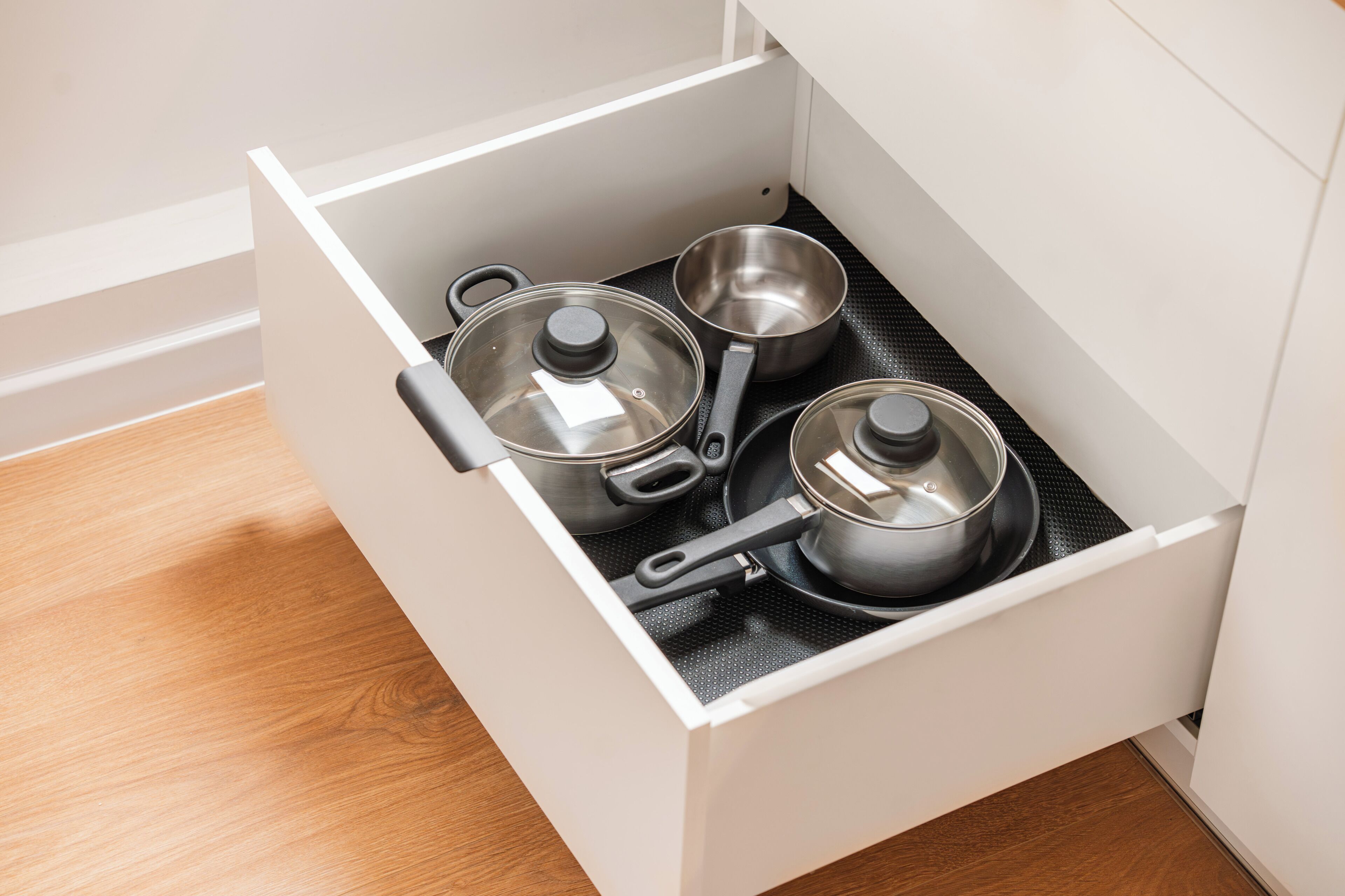 A kitchen drawer with pots and pans.