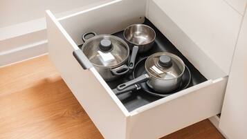 A kitchen drawer with pots and pans.