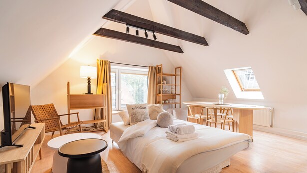 A bedroom with a bed, a desk, a chair, a TV, and a window. - RentPlanet - Apartamenty Raciborska (Gliwice)