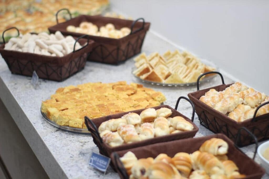 Ein Buffet mit verschiedenen Backwaren, darunter Kuchen, Gebäck und Brot.