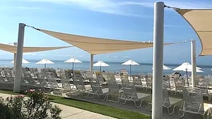 A beachside lounge area with rows of sun loungers and umbrellas, overlooking the ocean. - 3BR Seabrook Home, Pet Friendly, Near Beach-Pools, Golf, Equestrian and Tennis (Seabrook Island)