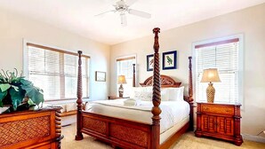 A four-poster bed with a wooden headboard, a ceiling fan, and two bedside tables with lamps. - 3BR Seabrook Home, Pet Friendly, Near Beach-Pools, Golf, Equestrian and Tennis (Seabrook Island)