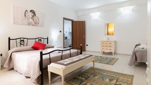 Un dormitorio con cama, banca, cómoda, espejo y un cuadro en la pared.