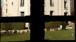 A symmetrical building with two prominent towers, a central entrance, and a well-maintained lawn. - Atypical stay in a green setting, 20 minutes from Les Sables d'Olonne. (Les Achards)