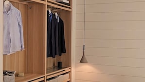 Une chambre à coucher avec un lit, une armoire et un luminaire suspendu.