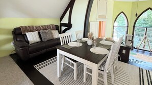 Un espace repas comprenant une table et des chaises, un canapé et une vue sur l’extérieur.