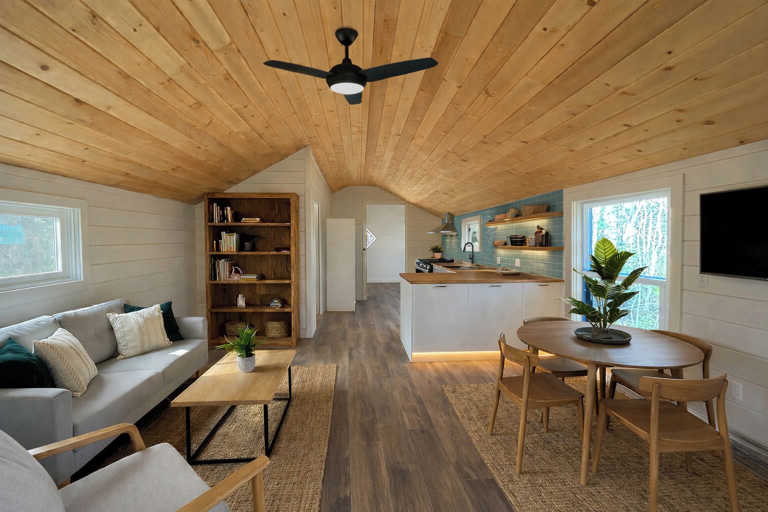 Un intérieur chaleureux avec un plafond en bois, un espace de vie comprenant un canapé et une table basse, une cuisine avec un bar et un coin repas avec des chaises.