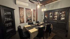 A dining area with a table set for six, surrounded by dark wooden cabinets with glass doors displaying china.