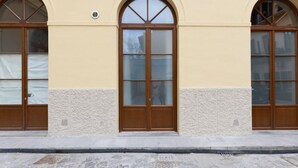 A building facade with three arched windows, a central door with glass panels, and a textured wall. - A bright and welcoming 50 square meters apartment, perfect for four people, located on the ground floor of the former headquarters of the Alinari Foundation, a completely renovated historic building.The property is located in the Santa Maria Novella area (Florence)