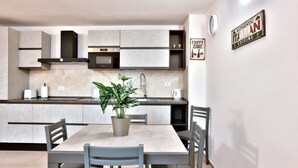 A modern kitchen with built-in appliances, a dining table with chairs, and a potted plant. - A bright and welcoming 50 square meters apartment, perfect for four people, located on the ground floor of the former headquarters of the Alinari Foundation, a completely renovated historic building.The property is located in the Santa Maria Novella area (Florence)