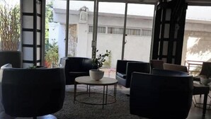 Ein modernes Interieur mit einem runden Tisch, zwei schwarzen Stühlen und einem Blumentopf.