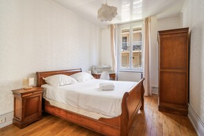 A bedroom with a wooden bed, a nightstand, a desk, and a wardrobe. - Lyon 6 Foch: Quiet 1-bedroom apartment with workspace (Lyon)