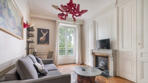 Ein Wohnzimmer mit Kamin, einer Couch, einem Couchtisch und einem Fernseher.