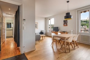 Un appartement moderne comprenant un coin repas, une cuisine et offrant une vue sur la ville.