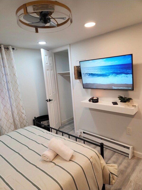 A bedroom with a bed, a television on a wall, a ceiling fan, and a door leading to a closet. - Cozy Hotel Like Room in Avenel with Private bathroom and Laundry. (Woodbridge Township)