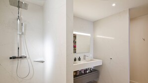 Un baño moderno con ducha, lavamanos y espejo.