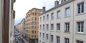 Une rangée d’immeubles à étages multiples, caractérisés par une architecture uniforme, notamment au niveau des fenêtres et des balcons.