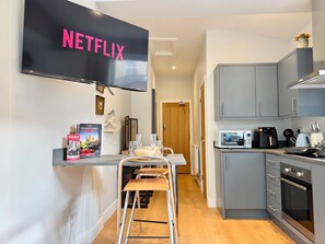 Una cucina moderna con mobili grigi, forno integrato e microonde.