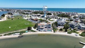 Zona residencial costera con casas, un tanque elevado grande y una playa.