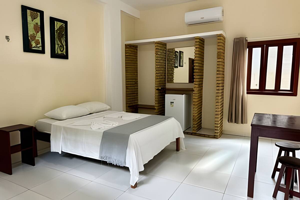 Ein Hotelzimmer mit Bett, Schreibtisch und Kühlschrank.