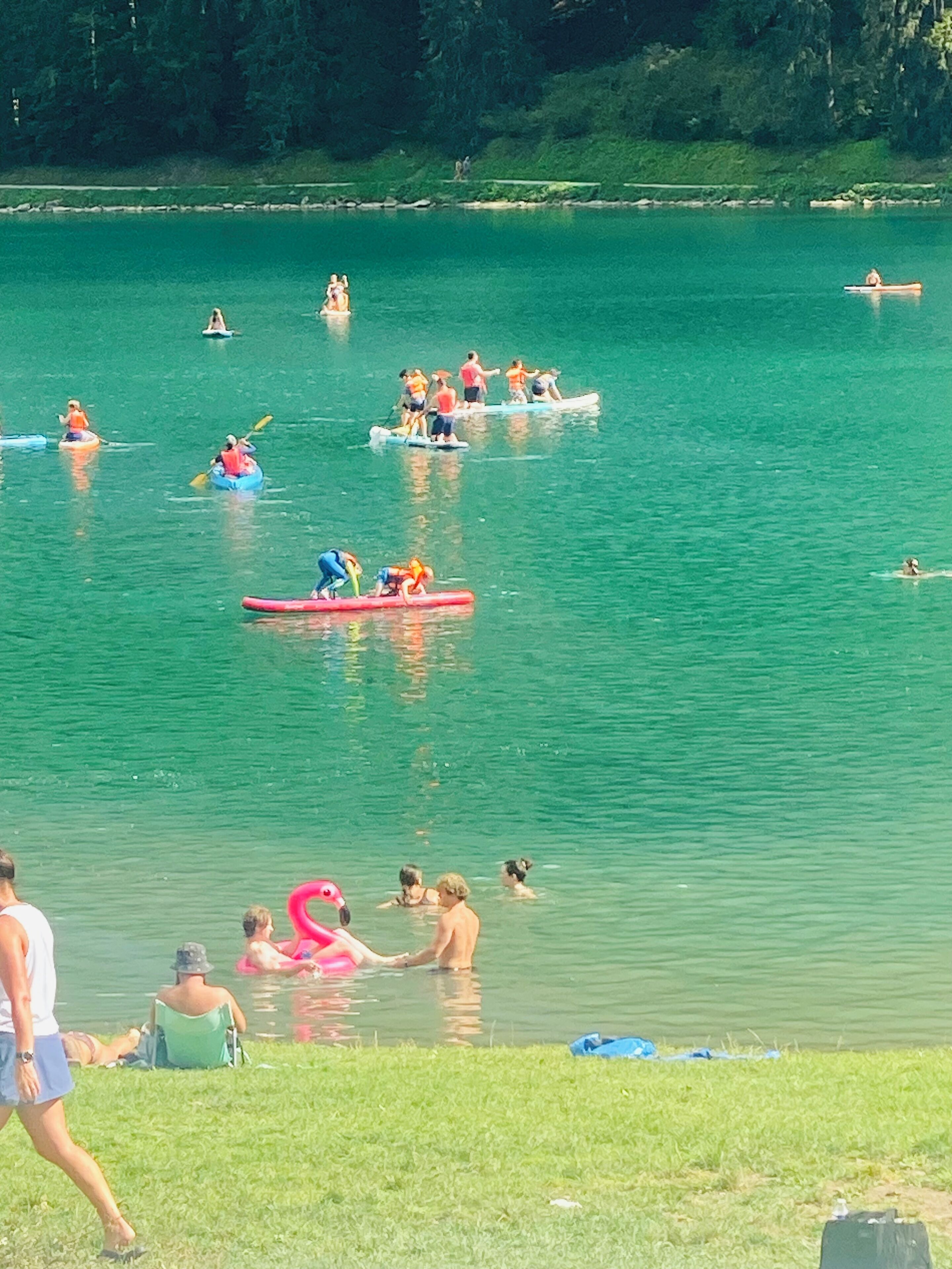 A lake with people kayaking and swimming.