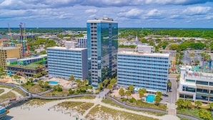 Een hoog hotel met meerdere verdiepingen, een zwembad en een strandgedeelte.